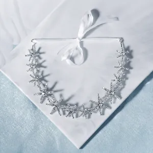 Close-up of silver star headband with rhinestones and white satin ribbon ties
