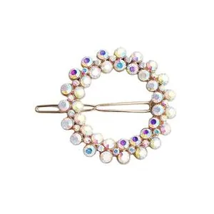 Detail of round gold hair clip with rainbow rhinestones and classic snap fastener