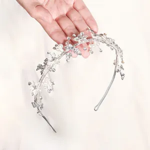 Detalle de diadema artesanal con flores de cristal, perlas y hojas de acabado plateado
