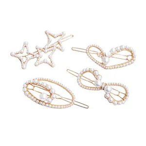 Detailed view of 4-piece gold hair clip set with elegant pearls in heart and bow shapes