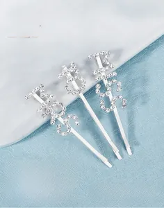 Detailed close-up of MRS and BOSS rhinestone hair clips with hand-wired crystal detail