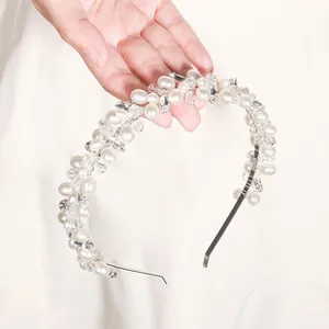 Detalle de una diadema brillante con perlas y cristales sobre una banda de metal plateado