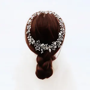 Elegant silver bridal headband with white pearls and metal leaves on braided hair