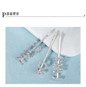 Detailed close-up of three silver rhinestone hair clips with MISS, LOVE and MRS lettering