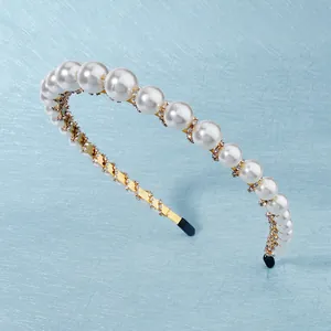 Elegant gold metal headband featuring white pearls and sparkling rhinestones on blue background