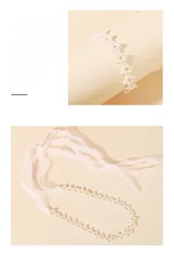 Détail de collier perlé avec strass et rubans blancs translucides pour les cheveux