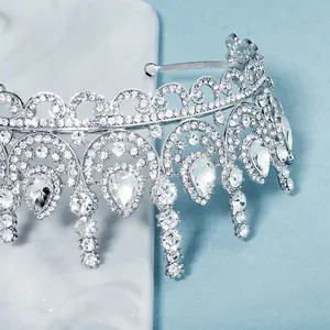 Elegant silver bridal crown with teardrop rhinestones on a white marble stand