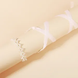 Collier ras du cou élégant en perles blanches avec rubans en soie sur fond beige
