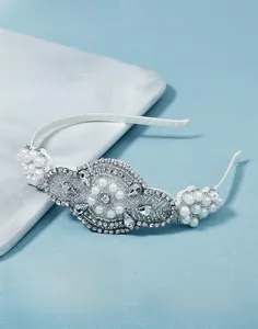 Macro shot of French bridal headband with hand-sewn white pearls and sparkling rhinestones