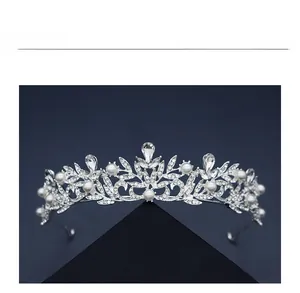 Detailed macro view of silver bridal crown featuring pearls and rhinestones on blue background
