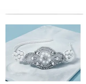 Macro shot of bridal headband with hand-sewn pearls and rhinestones on marble surface