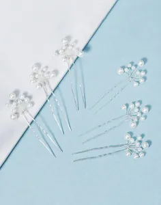 Detail of six handmade U-shaped hair pins with white pearls and silver wire craftsmanship