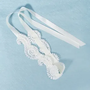 Elegant white lace bridal headband with satin ribbons on a light blue textured background