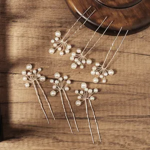 Handmade pearl hair pins set with floral cluster design on vintage wooden background