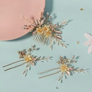 Dettaglio set sposa con pettine floreale, forcine a U, cristalli e foglie dorate eleganti