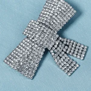 Pinza para el pelo con lazo de diamantes de imitación y montura de plata sobre azul