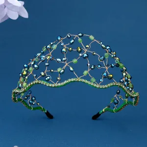 Dettaglio di fascia per capelli in rete dorata con cristalli blu e pietre verdi