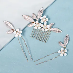 Three-piece bridal hair set with white pearl flowers and metal leaves on a blue background