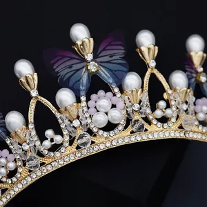 Golden bridal crown with pearls, blue-purple butterflies and rhinestones for weddings