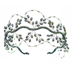 Close-up of handmade crystal beaded bridal crown with emerald rhinestones and dark gems