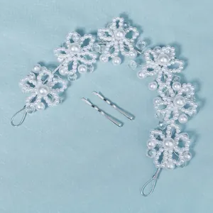 Handmade bridal hair vine with white pearls and crystals on light blue background