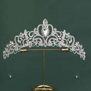 Detail of silver bridal crown with intricate rhinestone scrolls and pear-cut center stone