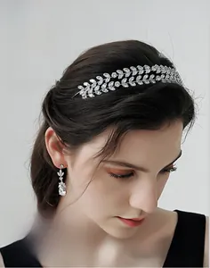 Detailed close-up of a silver leaf bridal headpiece and matching teardrop zircon earrings