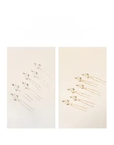 Detail of handmade U-shaped hair pins with gold and silver crystal pearl leaf design