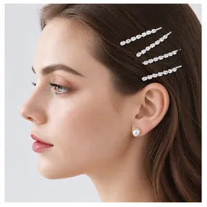 Detail of model wearing silver zircon hair clips and elegant white pearl earrings
