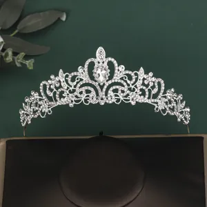 Macro detail of silver tiara with water-drop crystal and rhinestones on black cushion