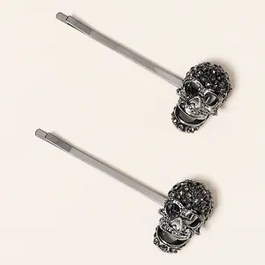 Detalle de horquillas góticas de esqueleto con pedrería gris oscuro y acabado metal