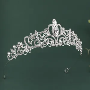 Macro detail of bridal crown featuring baroque silver leaf patterns and large pear-cut zircon