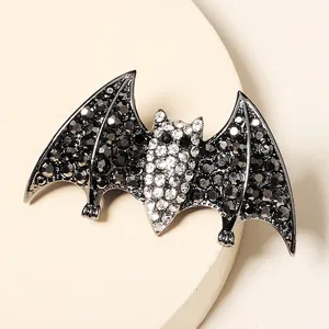 Halloween bat hair clip with sparkling black and white rhinestones on a beige tray