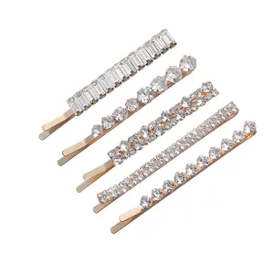 5-piece set of golden geometric rhinestone hair pins with sparkling crystals on white background