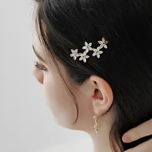 Elegante bloemen haarklem en lineaire kristallen oorbellen set in goudkleur voor dames