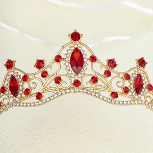 Detail of baroque gold tiara with large red oval gems and crystal rhinestones