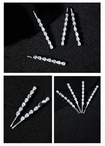 Macro shot of silver metal hair clips with shiny teardrop zircon stones on a black base
