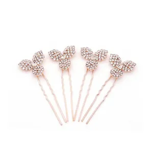 Détail de quatre épingles à cheveux en or rose avec cristaux blancs et motif floral