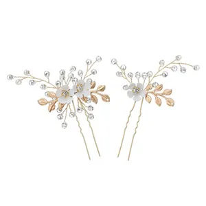 Close-up of elegant floral hair pins with gold leaves, white petals and clear beads