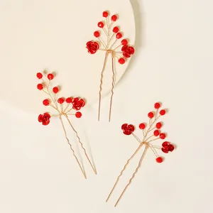 Détail de 3 épingles à cheveux de mariée avec fleurs en cristal rouge et métal doré en U