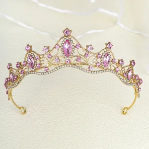 Macro detail of luxury gold bridal crown with sparkling pink marquise rhinestones