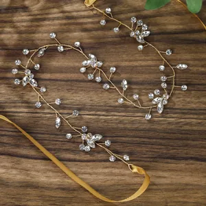 Elegant gold bridal hair vine with sparkling crystals and ribbons on a rustic wood background