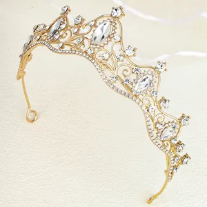 Detailed view of luxury gold bridal tiara featuring white rhinestones and baroque waves
