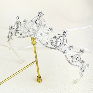 Detailed view of silver bridal crown with teardrop crystals on a textured fabric