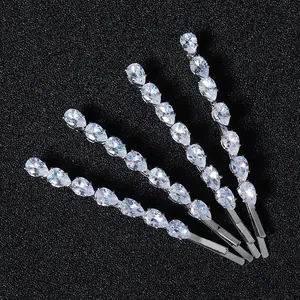 Set of four silver metal hair pins with inlaid sparkling zircons on a dark background