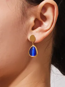 Nahaufnahme goldener Tropfenohrringe mit Katzenaugeneffekt im eleganten Vintage-Stil