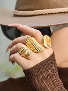 Detailaufnahme von gehämmerten und texturierten vergoldeten Ringen an einem Model