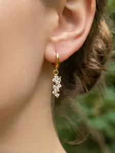 Dettaglio di orecchini a nappa placcati oro 18k con zirconi marquise su una modella