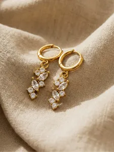 Dettaglio di orecchini a cerchio placcati oro 18k con ciondoli in zircone a foglia