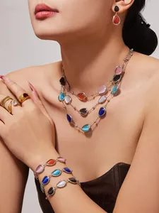 Nahaufnahme von mehrlagigen Halsketten und Armbändern mit tropfenförmigen Katzenaugensteinen